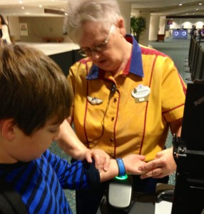 A Cast Member shows my son how to use his MagicBand at our first spot -- Disney's Magical Express